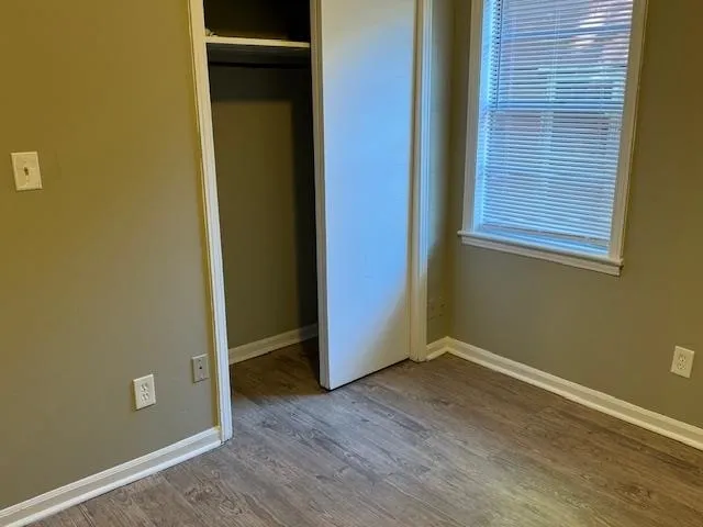 a view of empty room with wooden floor