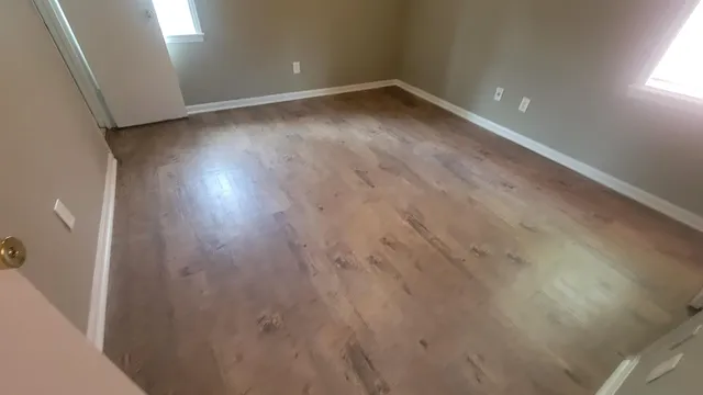 a view of empty room with wooden floor