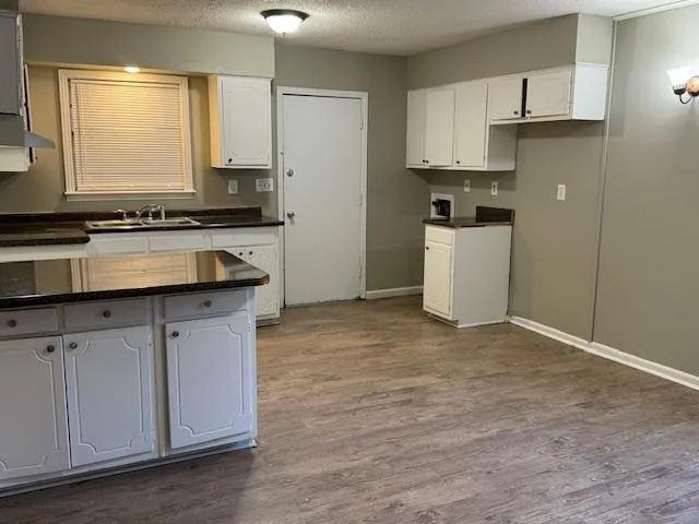 a kitchen with stainless steel appliances white cabinets sink and a refrigerator