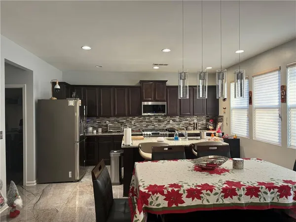 a large kitchen with a table and chairs