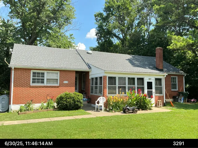 a view of a house with a yard and potted plants