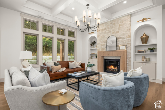 1175 North Elk Rdg Lane, Unit 201 Alpine, UT 84004 - Photo 11 of 38 Coffered ceiling with a chandelier, stone-clad fireplace with a wood mantel, built-in arched shelving, large multi-pane windows, and wood-finish flooring
