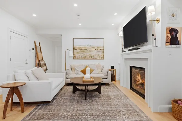 a living room with furniture a flat screen tv and a fireplace