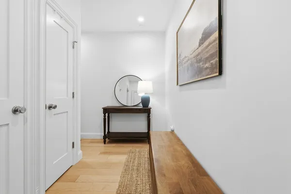 a view of a hallway with wooden floor and staircase