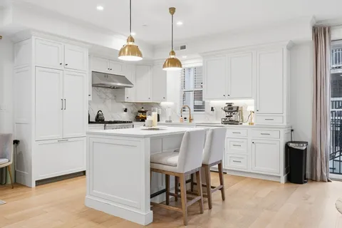 a kitchen with white cabinets and stainless steel appliances