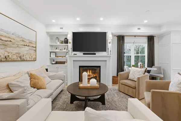 a living room with furniture a flat screen tv and a fireplace