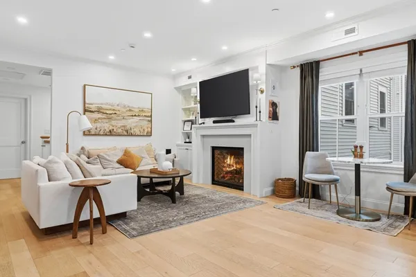a living room with furniture a flat screen tv and a fireplace