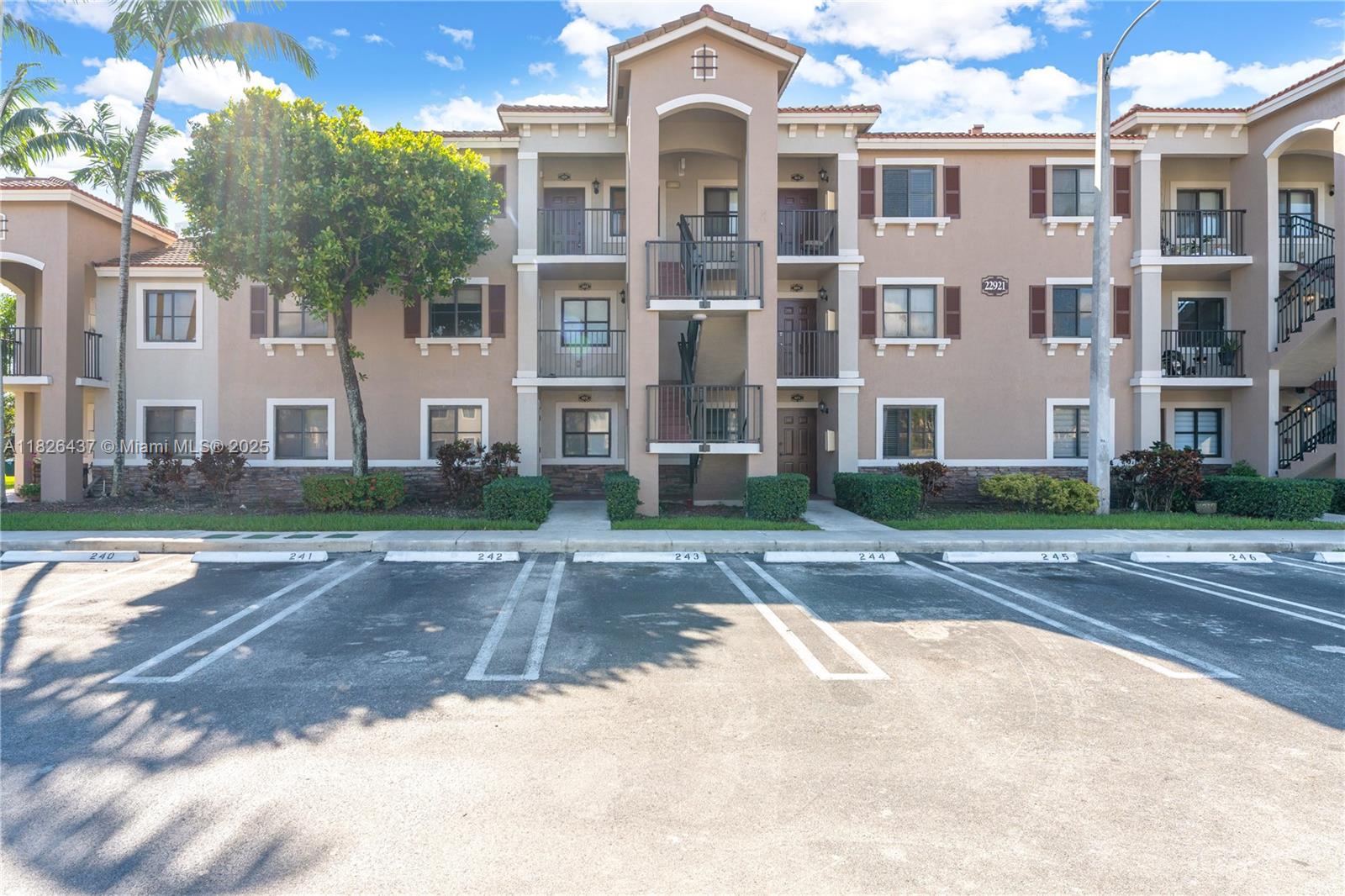 22921 Southwest 88th Place, Unit 301 Cutler Bay, FL 33190 - Photo 1 of 24 a view of a building with a yard