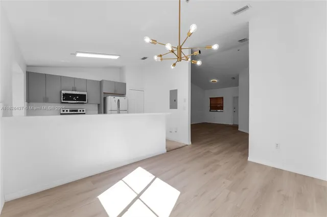 a view of a kitchen with a dishwasher a kitchen island with wooden floor