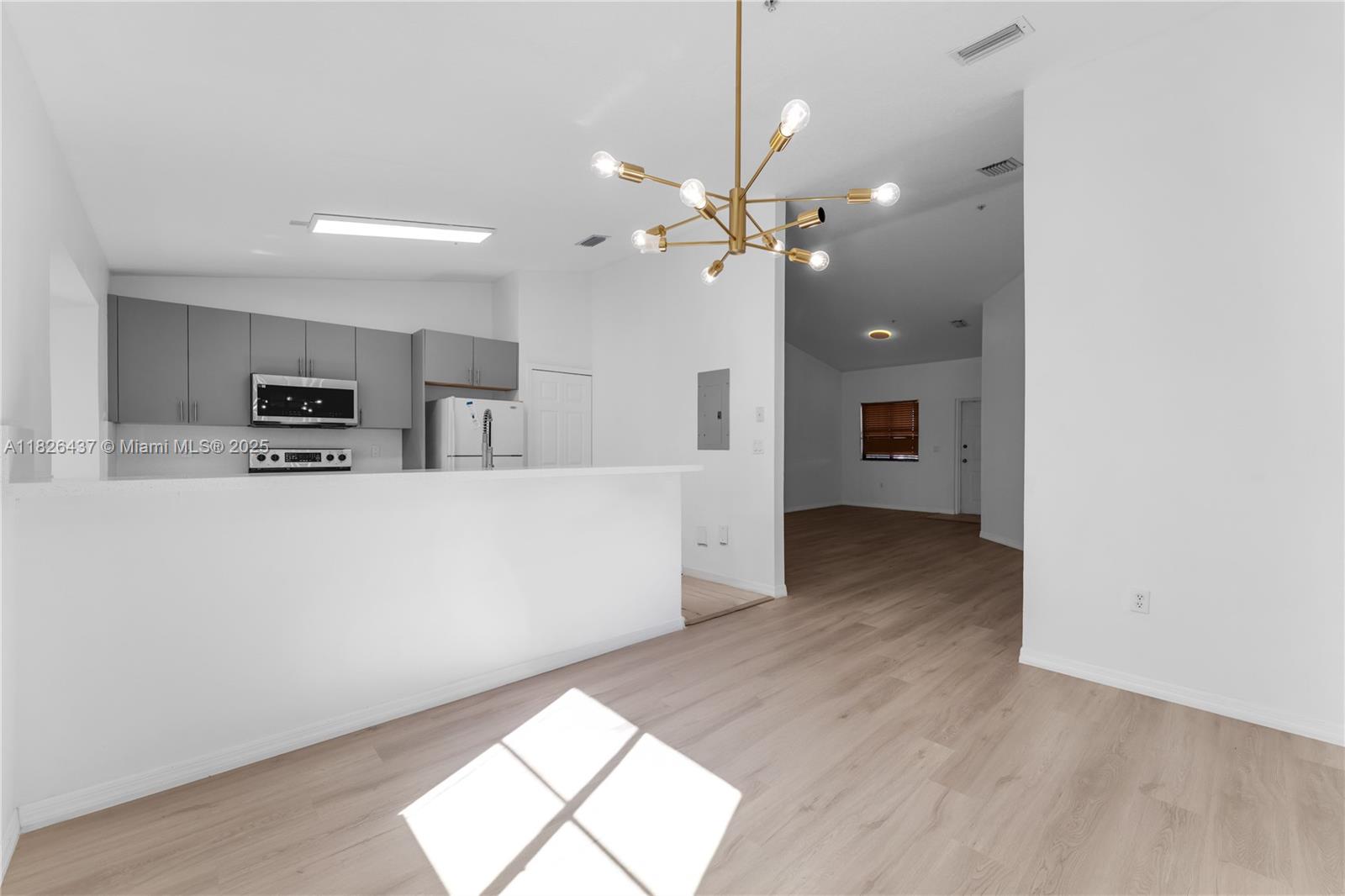 22921 Southwest 88th Place, Unit 301 Cutler Bay, FL 33190 - Photo 11 of 24 a view of a kitchen with a dishwasher a kitchen island with wooden floor