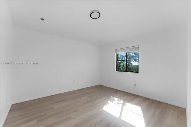 a view of room with hardwood floor and window