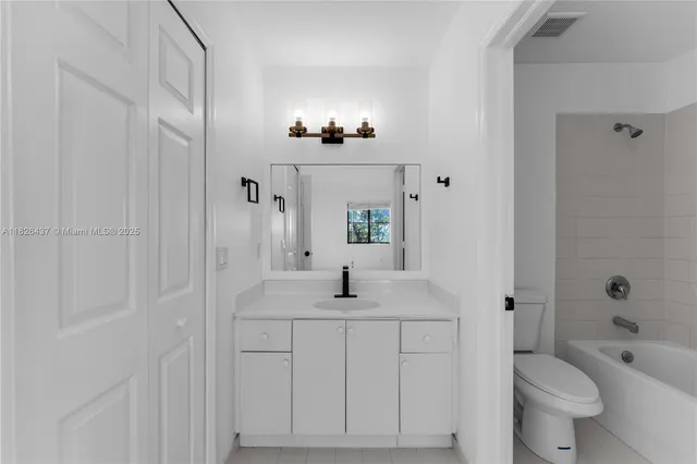 a bathroom with a granite countertop sink toilet a large mirror a vanity and shower