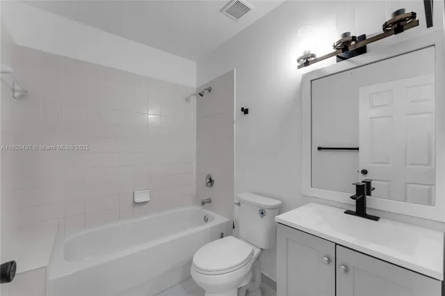 a bathroom with a granite countertop sink a toilet and a bathtub