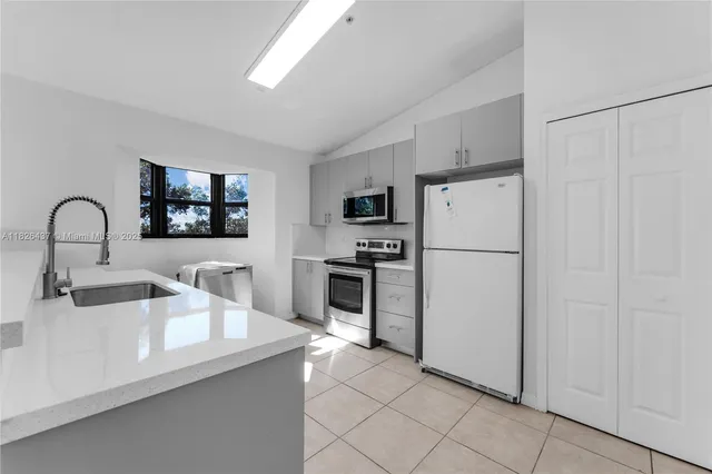 a kitchen with appliances a sink and cabinets