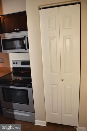 a kitchen with white cabinets and black appliances