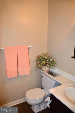 a white toilet sitting next to a bathroom sink and a mirror