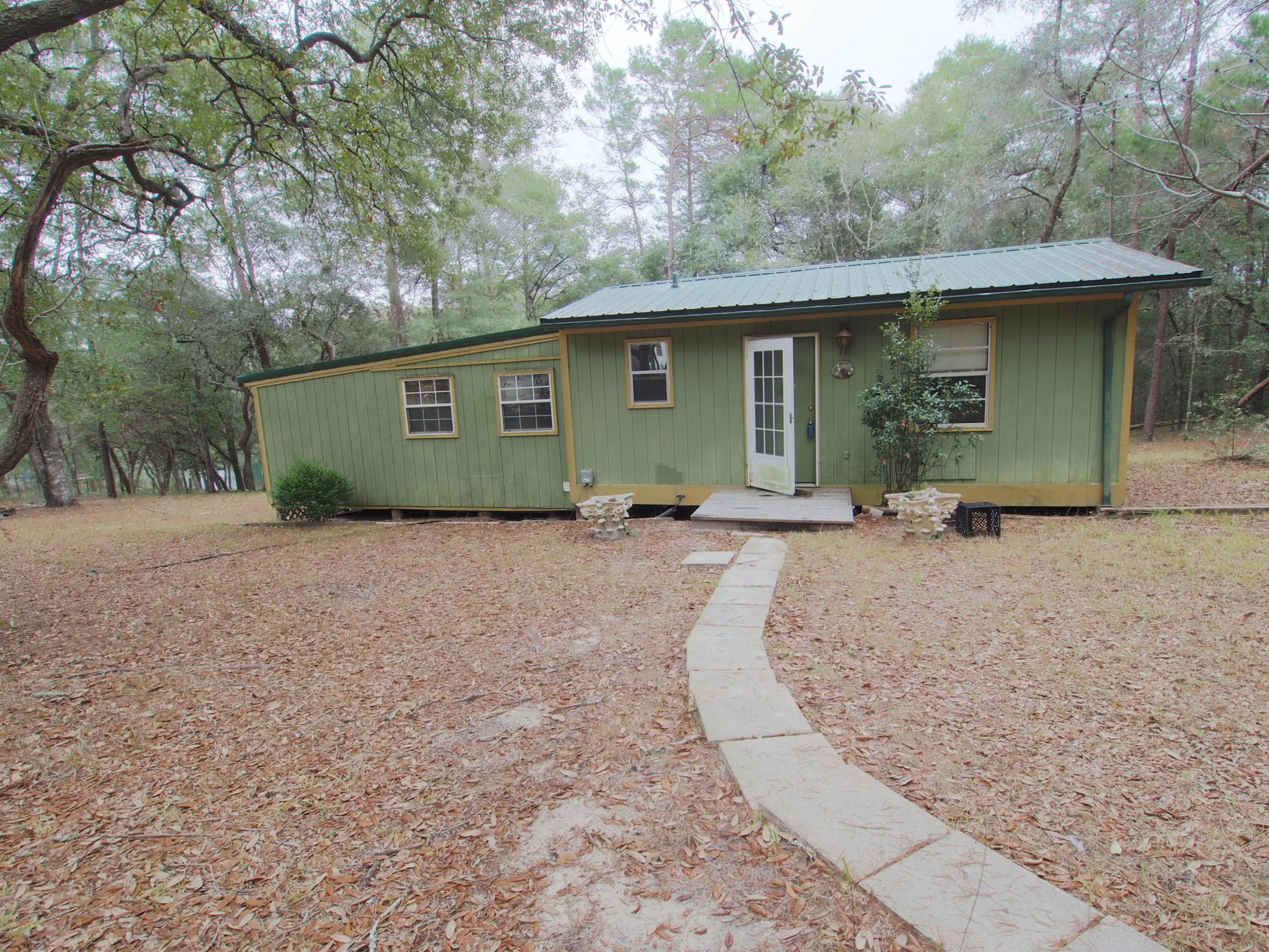 240 Roberts Road East DeFuniak Springs, FL 32433 - Photo 18 of 26 a front view of a house with a yard and pathway