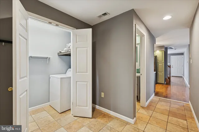 a view of a hallway with closet and bathroom