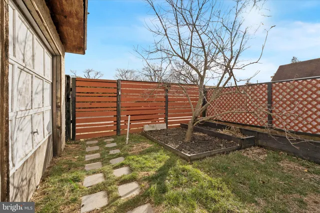 a view of a backyard with wooden fence