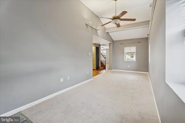 a view of a room with a ceiling fan and window
