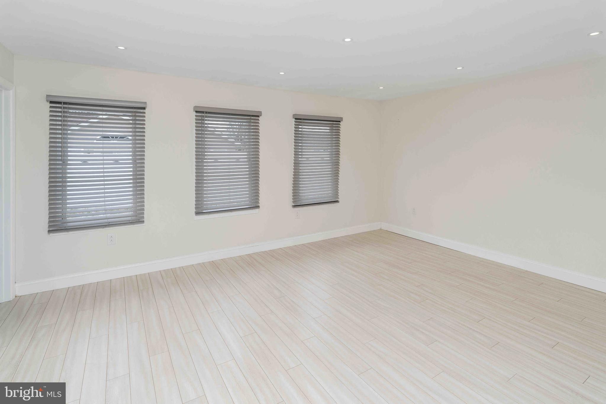 137 Idlewild Road Levittown, PA 19057 - Photo 13 of 34 an empty room with wooden floor and windows