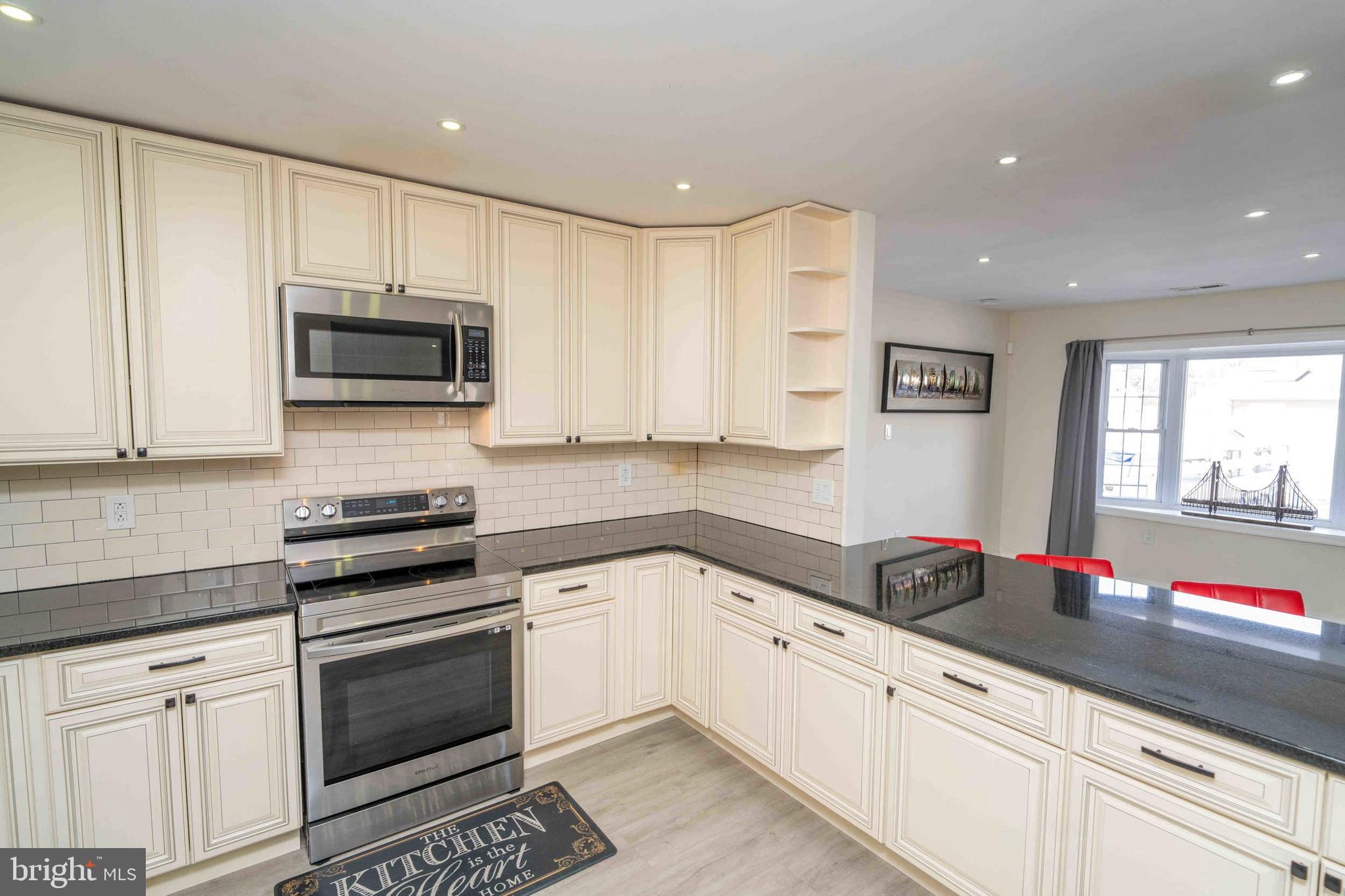 137 Idlewild Road Levittown, PA 19057 - Photo 5 of 34 a kitchen with granite countertop white cabinets and black appliances