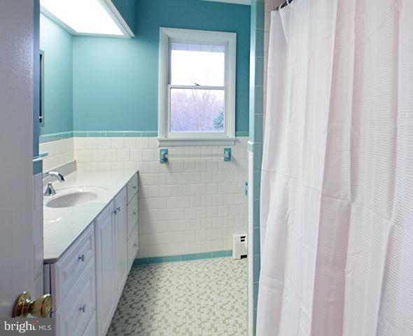 21315 Middletown Road Freeland, MD 21053 - Photo 20 of 30 a bathroom with a granite countertop sink a mirror and a bathtub