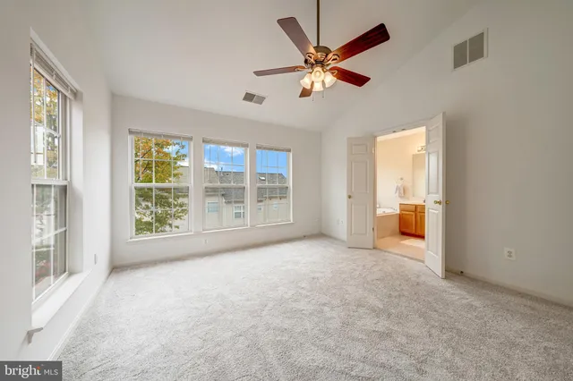 an empty room with closet and a chandelier fan
