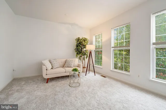 a view of an empty room with furniture and a window