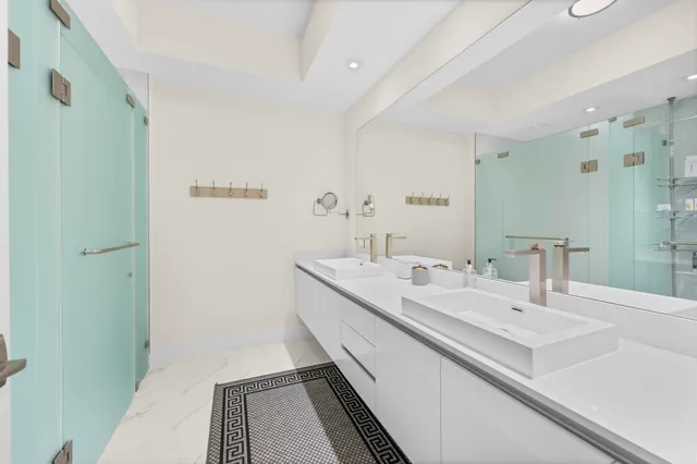 a bathroom with a double vanity sink mirror double and shower