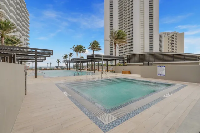 a swimming pool with outdoor seating and city view