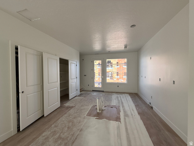 11023 South Freestone Road, Unit 122 South Jordan, UT 84009 - Photo 5 of 12 Spacious room featuring light wood-finish flooring, white walls, and a recessed ceiling light