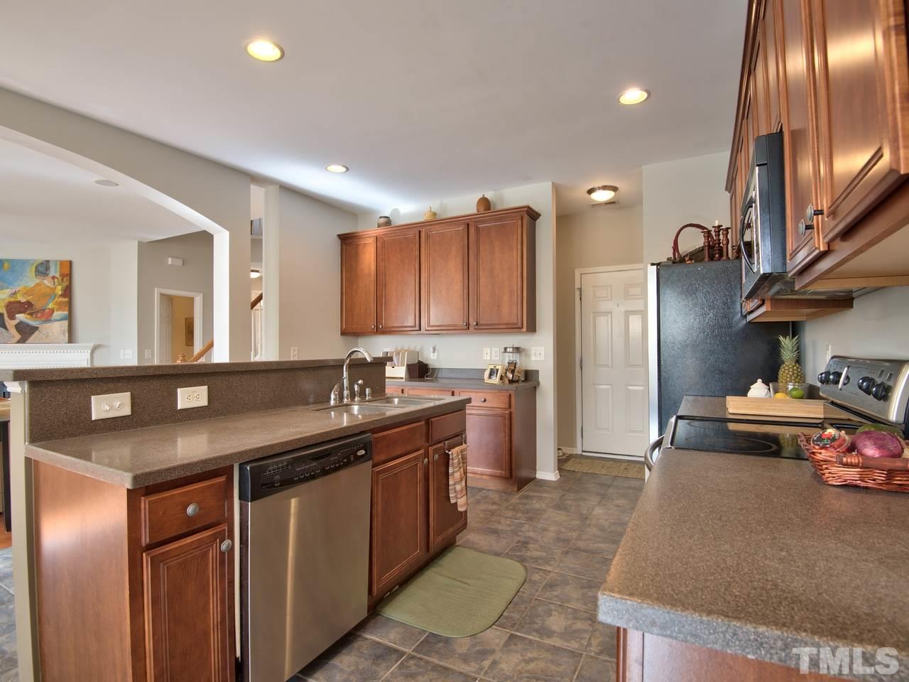 8415 Stonework Drive Raleigh, NC 27613 - Photo 11 of 24 a kitchen with stainless steel appliances granite countertop a sink a stove and a refrigerator