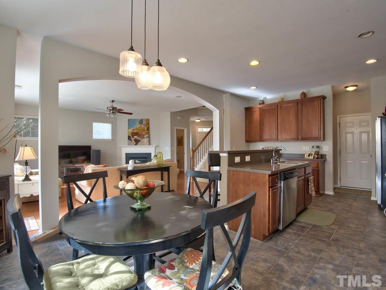 8415 Stonework Drive Raleigh, NC 27613 - Photo 13 of 24 a kitchen with stainless steel appliances granite countertop a stove a kitchen island a dining table and chairs