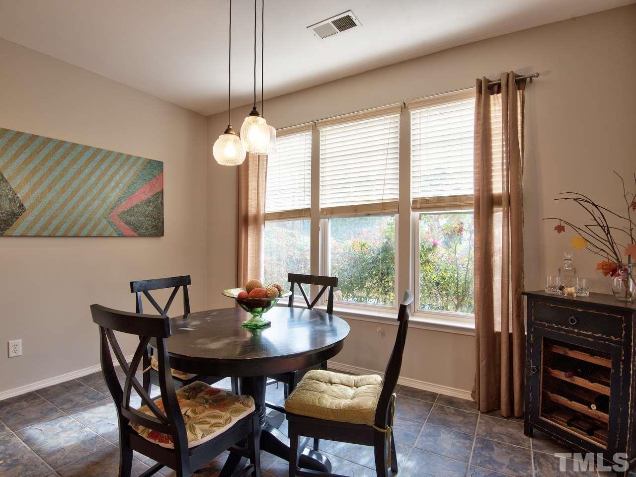 8415 Stonework Drive Raleigh, NC 27613 - Photo 14 of 24 a dining room with furniture a chandelier and wooden floor