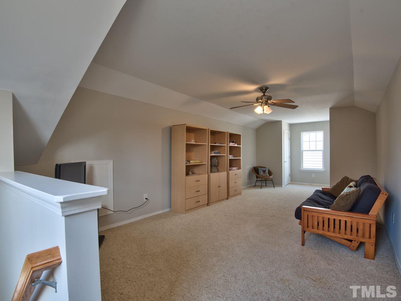 8415 Stonework Drive Raleigh, NC 27613 - Photo 23 of 24 a living room with furniture and a chandelier
