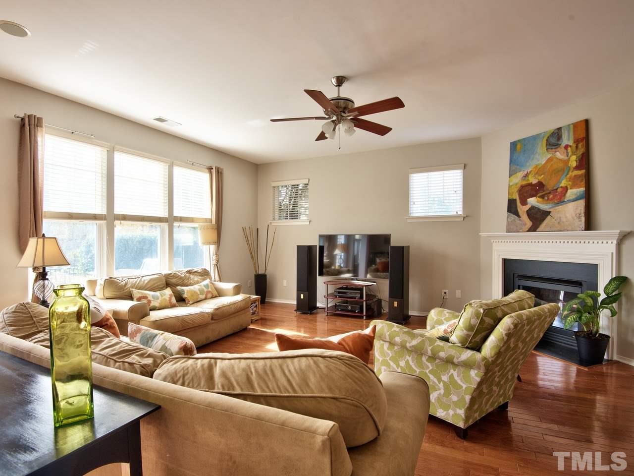 8415 Stonework Drive Raleigh, NC 27613 - Photo 7 of 24 a living room with furniture a fireplace and a large window