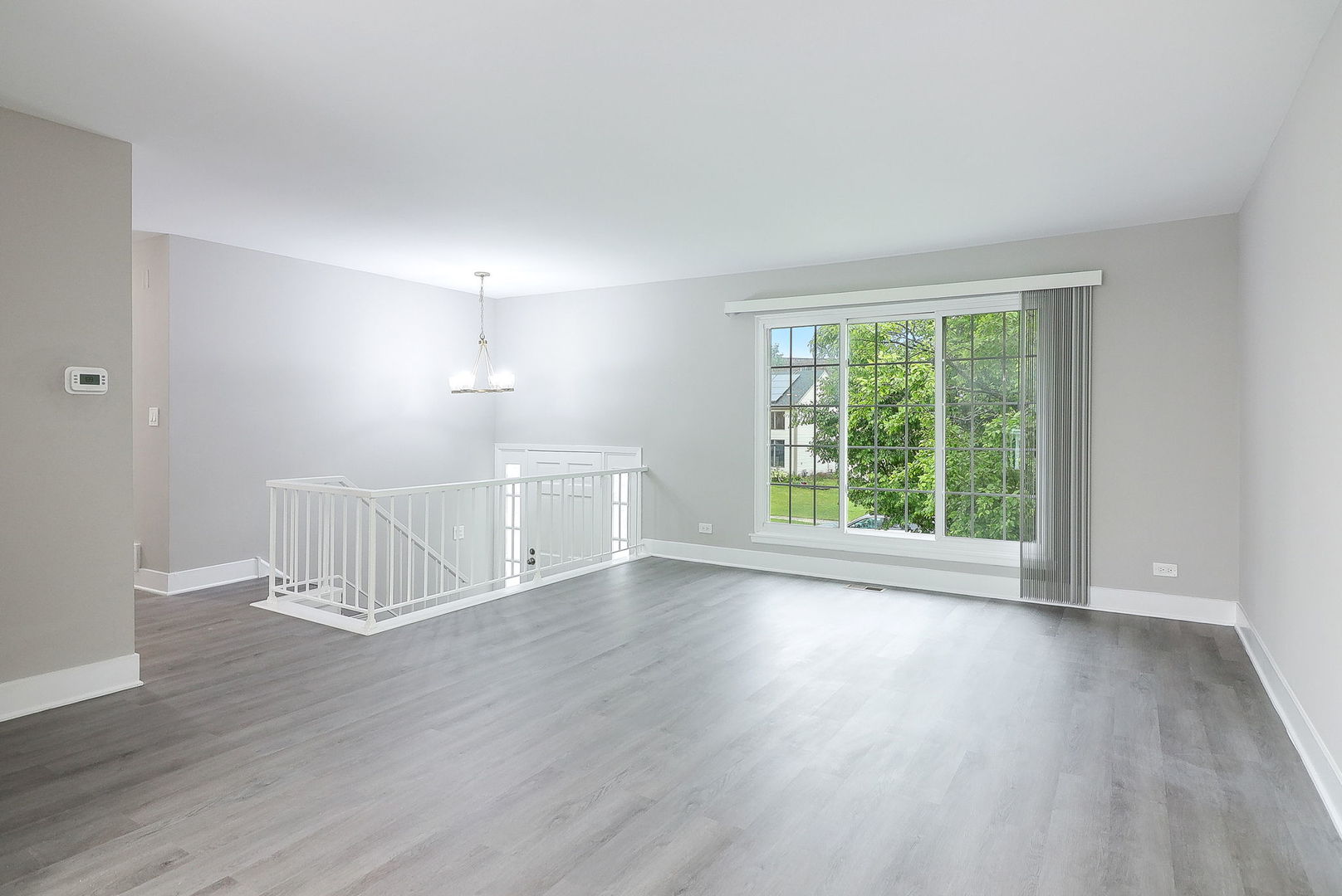 1914 Brookside Lane Hoffman Estates, IL 60169 - Photo 2 of 16 a view of an empty room with wooden floor and a window