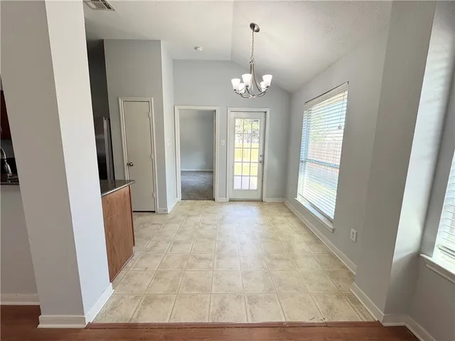 an empty room with chandelier and windows