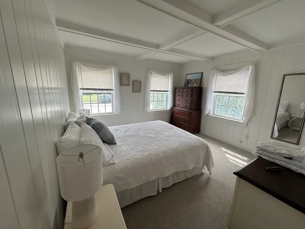 a bedroom with a bed and a flat tv screen on a dresser