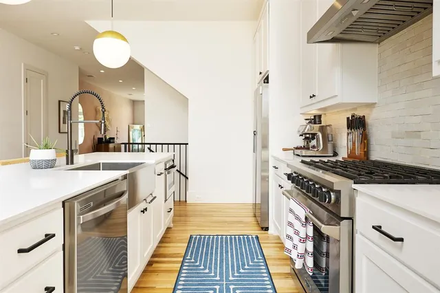 a kitchen with stainless steel appliances a sink stove and cabinets