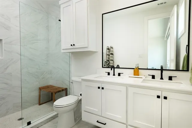 a bathroom with a sink a toilet and shower