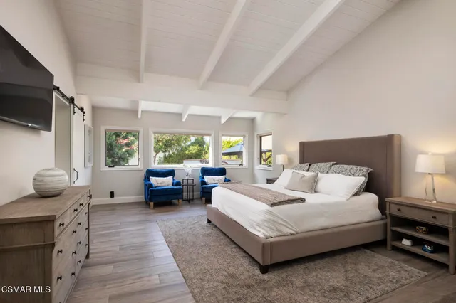 a spacious bedroom with a bed and a dresser in it