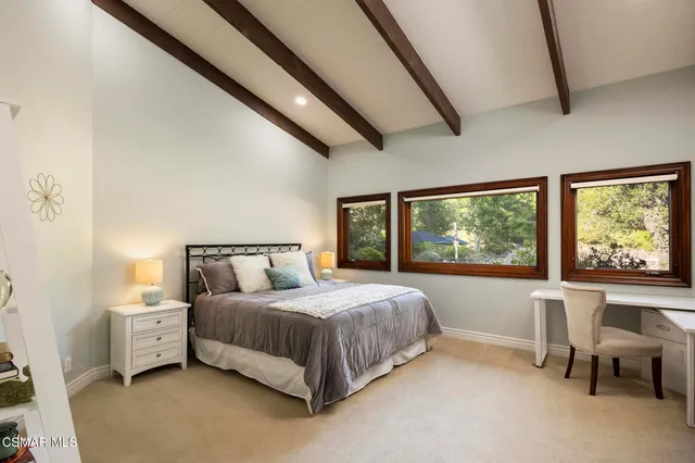 a dining room with furniture large windows and a chandelier