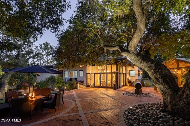 a view of a patio with table and chairs and a barbeque