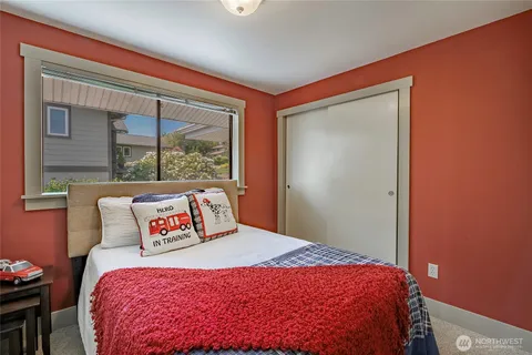 a bed sitting in a bedroom next to a window