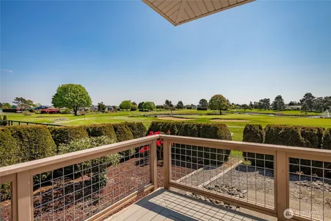 a view of a balcony with wooden floor & fence