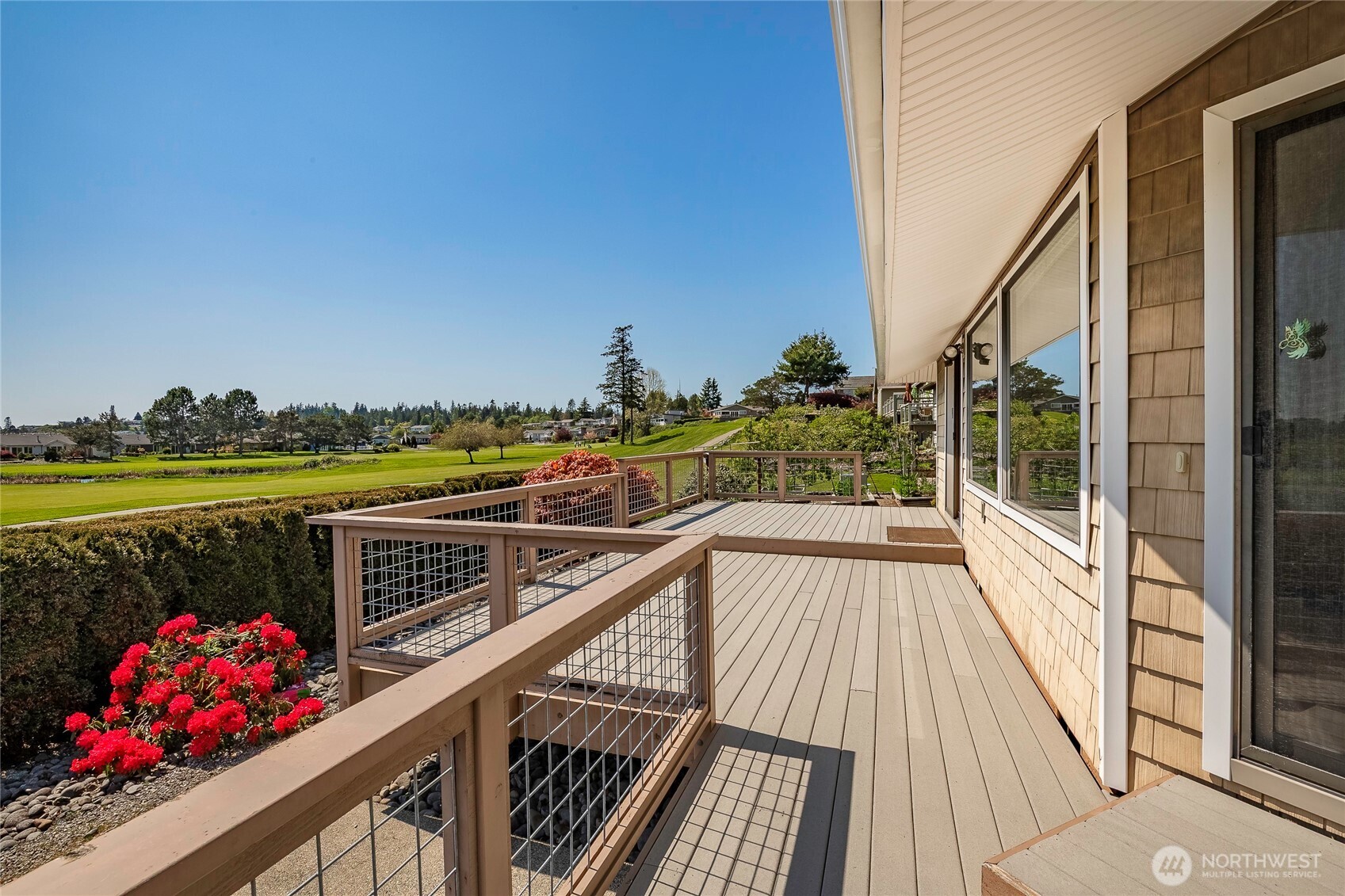 5537 Salish Road Blaine, WA 98230 - Photo 26 of 39 a view of a balcony with wooden chairs and floor to ceiling window