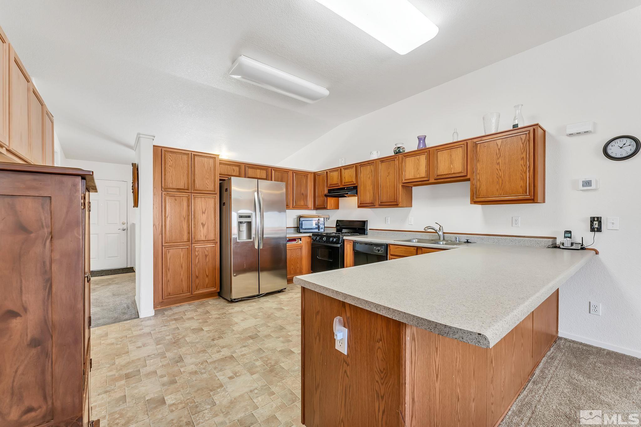 17541 Desert Lake Drive Reno, NV 89508 - Photo 10 of 33 a kitchen with stainless steel appliances a refrigerator sink and stove