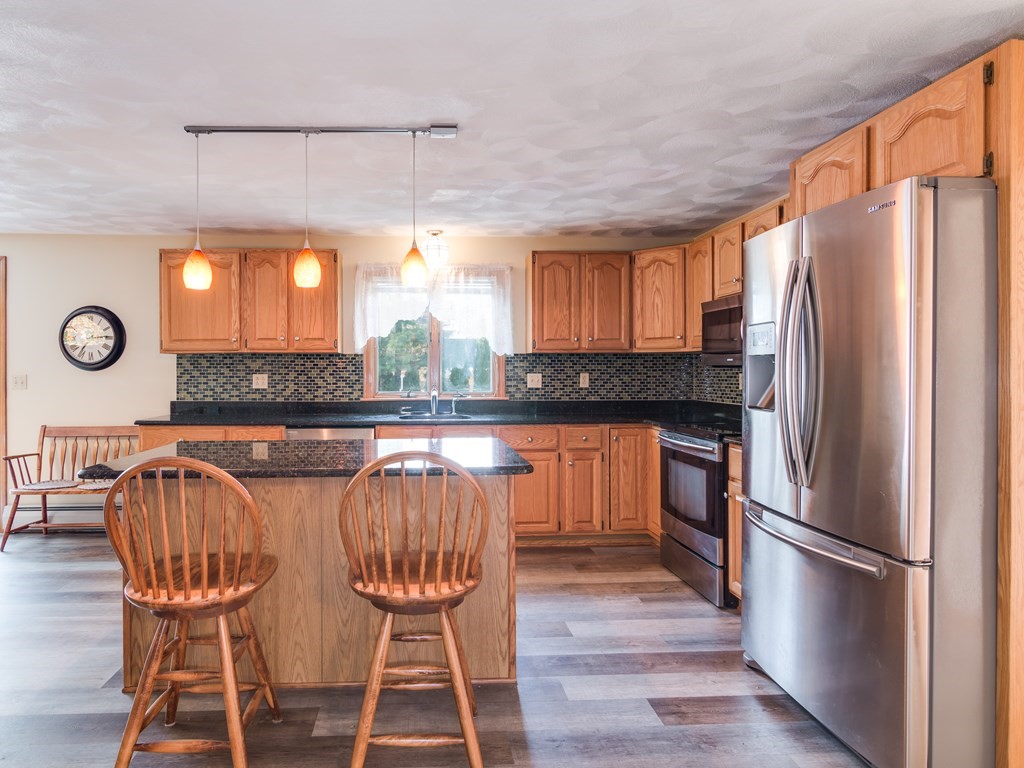 7 Old Town Road Beverly, MA 01915 - Photo 13 of 35 a kitchen with stainless steel appliances granite countertop a refrigerator a stove a sink and white cabinets with wooden floor